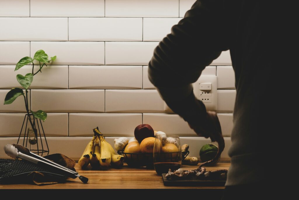 A person preparing a healthy meal with fruits and vegetables to boost immunity.