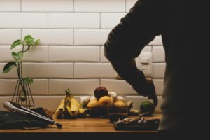 A person preparing a healthy meal with fruits and vegetables to boost immunity.